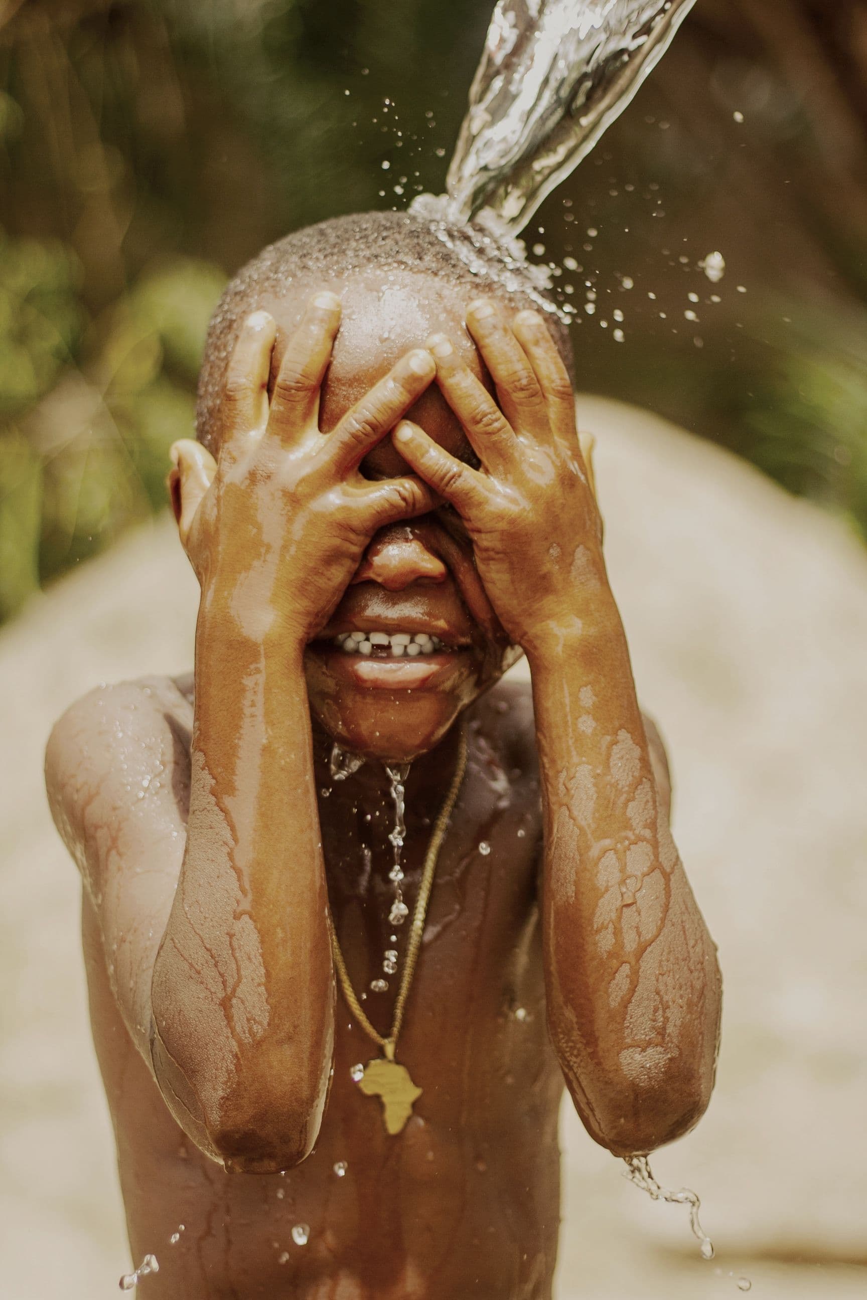 Criança sendo refrescada com água limpa
